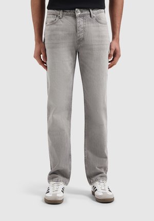 Light gray denim jeans with a straight-leg fit, five-pocket design, and subtle fading. Paired with white sneakers featuring gray accents.