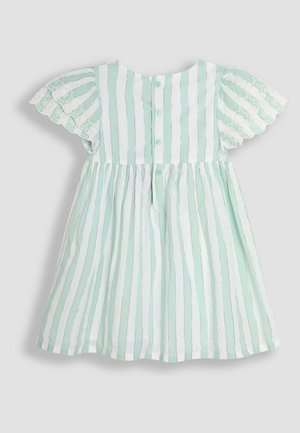 Svetlo mätovo zelené šaty s bielymi pruhmi a zlatými detailmi. Obsahujú krátke, volánkové rukávy a zapínanie na gombíky na zadnej strane. Hladká textúra látky.