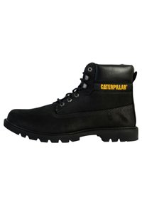 Black leather work boot featuring a lace-up design, padded collar, textured accents, and a rubber sole with deep treads. Yellow logo detail.