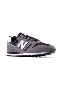 Zapatillas gris de ante y malla con un logo blanco, acentos negros, suela acolchada y suela de goma texturizada.