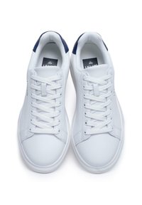 Witte sneakers met een gladde leren afwerking, voorzien van een marineblauwe achteraccent, platte veters en een gewatteerde kraag voor comfort.
