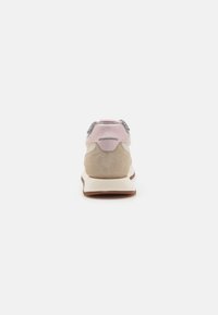 Sneaker with a beige, pink, and grey suede upper, rounded shape, padded collar, and white midsole; rear view showcases color blocking.