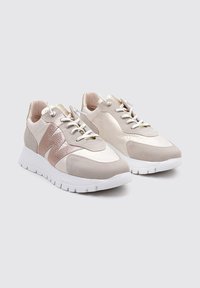 Zapatillas deportivas en color beige y rosa claro, fabricadas con materiales lisos y de ante, con una suela blanca, acentos texturizados y cierre de cordones.