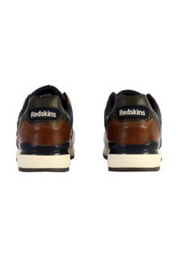 Zapatillas con una parte superior de malla en azul marino oscuro, acentos en cuero marrón, una entresuela blanca y detalles en negro en el talón con la marca "Redskins".