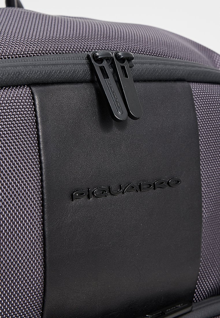 Borsa per laptop in tessuto grigio con superficie testurizzata, dotata di accenti in pelle nera, doppie cerniere e logo impresso.