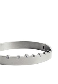 Metalowa bransoletka o szczotkowanej srebrnej powierzchni i gładkiej fakturze, z wzorem w zygzak oraz małymi, przezroczystymi kryształkami wzdłuż krawędzi.