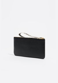 Borsa nera in pelle con superficie texture, zip dorata e un braccialetto con motivo. Design slim, ideale per i piccoli oggetti essenziali.