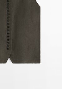 Dark olive green tailored vest with front button closure and pointed hem detail on a white background.