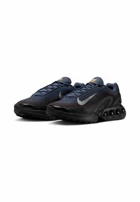 Scarpe sportive nere con parte superiore in rete, dotate di un logo Nike in argento, lacci testurizzati e una suola ammortizzata con dettagli circolari.