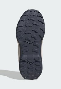 Sporta apavu zole ar detalizētu saķeres modeli, izgatavota no gumijas ar dažādiem zobratiem, galvenokārt tumši pelēkā krāsā.