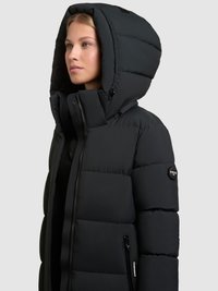Črna puffer jakna z velikim, oblazinjenim kapuco, sprednjimi zadrgami in stranskimi žepi. Ima sijoč logotip na rokavu.