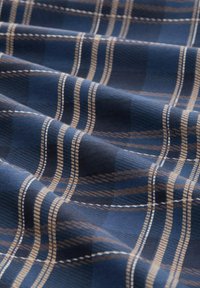 Navyblauer Stoff mit einem karierten Muster in Braun und Creme, mit glatter Oberfläche und feinen Nahtdetails.