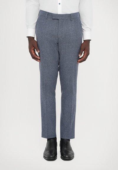 Tailored grey pants in a textured wool blend, featuring a flat front, slim fit, and crease down the legs, paired with black dress shoes.