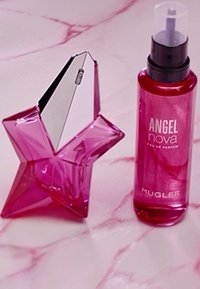 Stervormige glazen fles in felroze met een zilveren dop. Ernaast staat een transparante roze spuitfles met het etiket "ANGEL nova" van Mugler.
