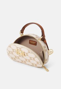 Beige strukturovaná kabelka vyrobená z potažené tkaniny, s logem zlaté barvy, hnědým koženým popruhem a zipovým uzávěrem. Interiér je podšitý látkou.