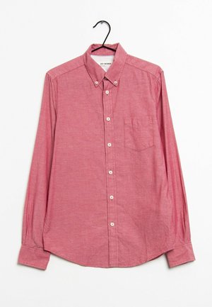 Rotes Langarmhemd mit Knöpfen und einer Brusttasche, das an einem schwarzen Kleiderbügel vor weißem Hintergrund hängt.