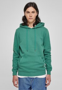 Hoodie verde realizzato in misto cotone, con tasca a marsupio, coulisse regolabile, polsini a costine e una vestibilità rilassata.