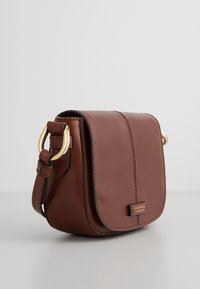 Borsa a tracolla in pelle marrone con chiusura a pattina, hardware dorato e superficie liscia. Presenta un dettaglio cucito e una placca con logo.