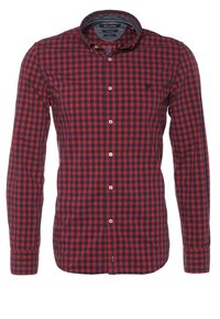 Chemise à manches longues à carreaux rouge et noir avec col et petit logo brodé sur la poitrine gauche.