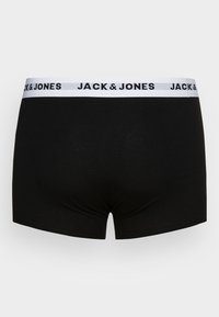 Boxer shorts noirs en tissu doux avec une ceinture blanche comportant le texte "JACK & JONES" en lettres noires.