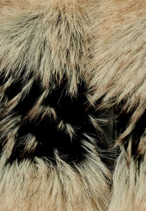Materiale in pelliccia sintetica beige e nera, caratterizzato da fili lunghi e leggeri. La texture appare morbida, con un aspetto stratificato che mette in evidenza il contrasto.