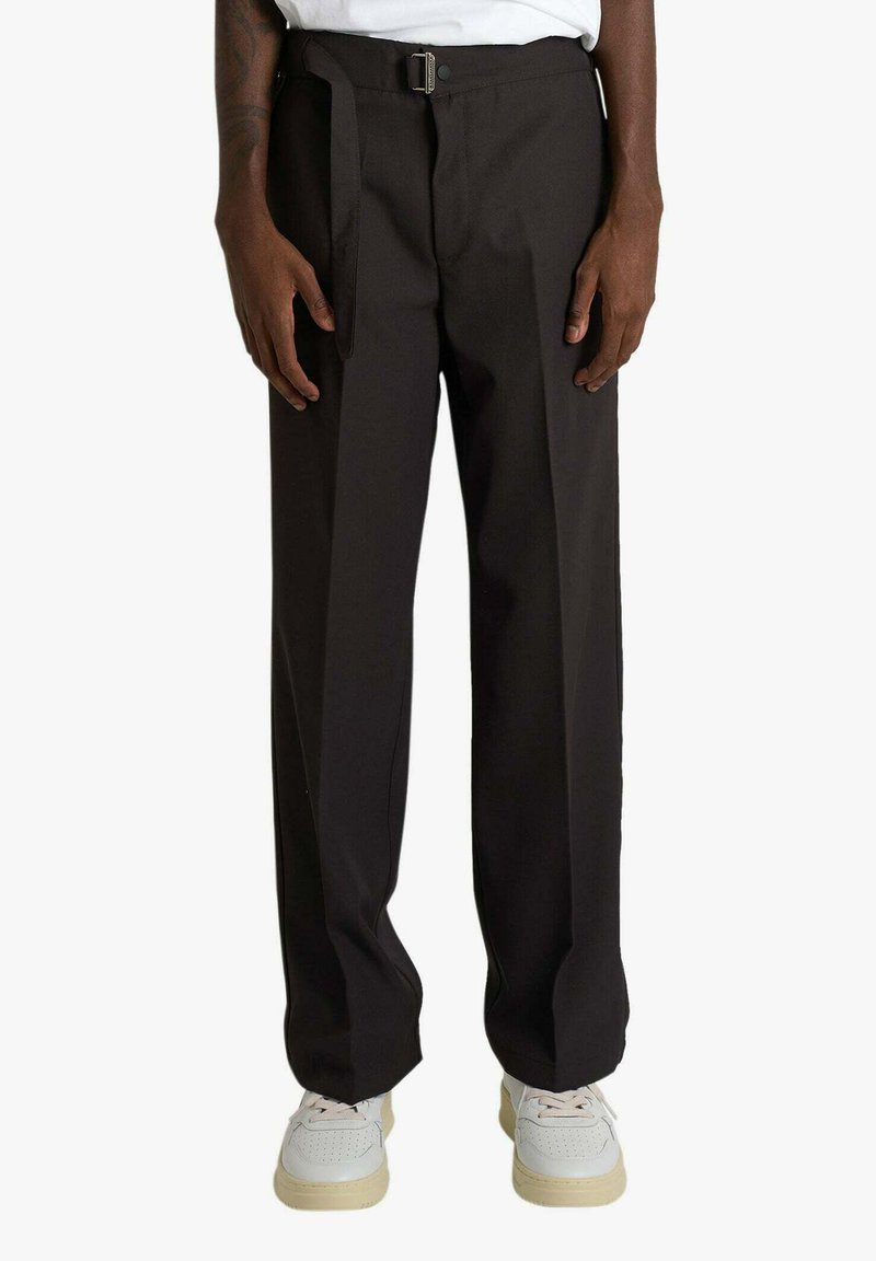 Pantaloni marrone scuro a vita alta con cintura, design a gamba dritta e fronte piatto, abbinati a sneakers bianche. Texture liscia.