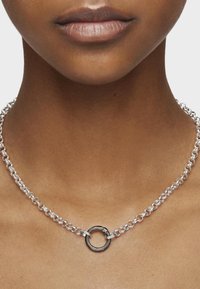 Collar de cadena de plata con eslabones ovalados entrelazados, que presenta un destacado acento circular en el centro, con un acabado elegante y pulido.