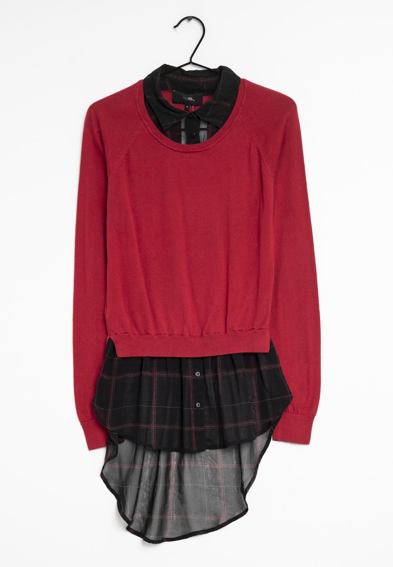 Pull en tricot rouge avec un ourlet de chemise à carreaux noirs, présentant un col rond, des manches longues et un design superposé avec un dos arrondi.
