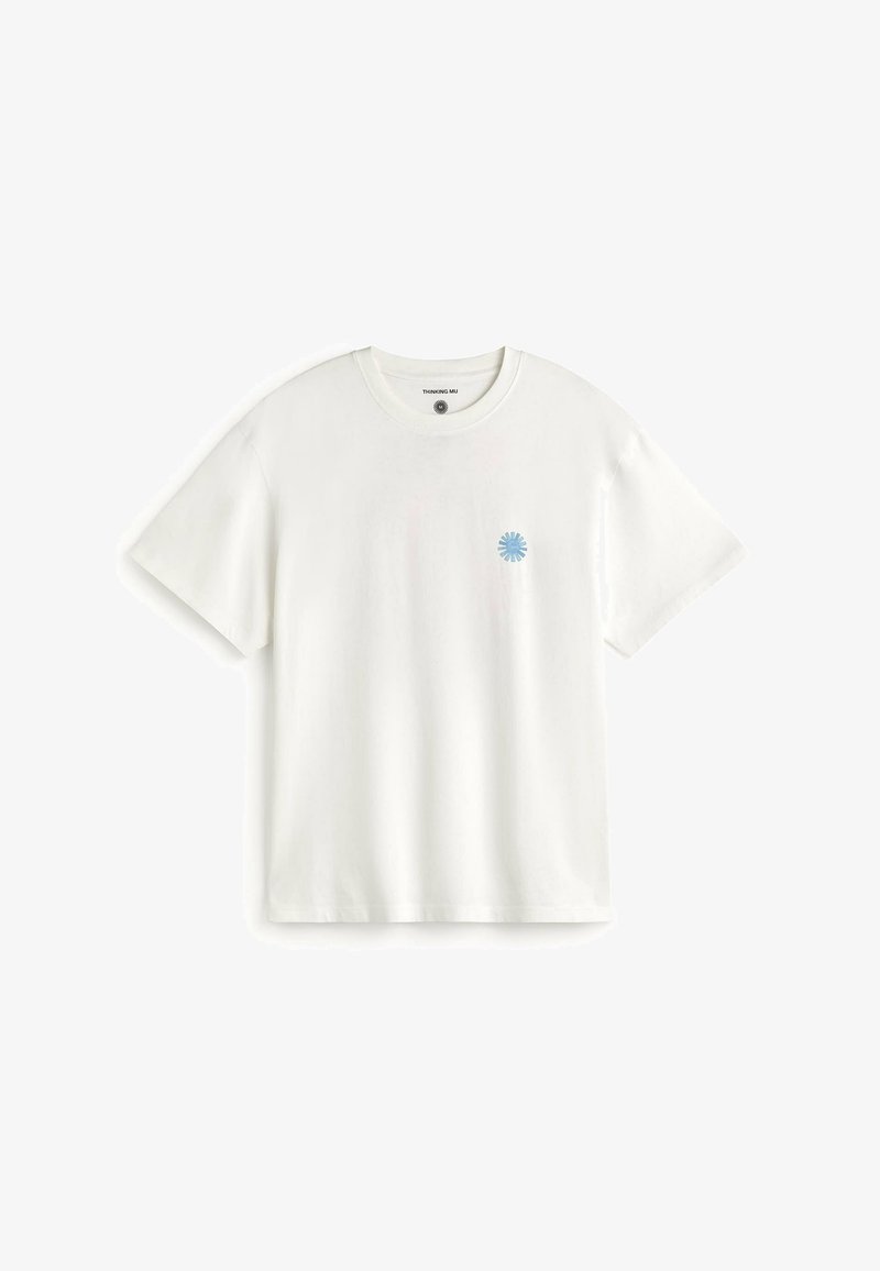 T-shirt blanc à manches courtes avec col rond et petit logo bleu éclat de soleil sur la poitrine gauche, présenté sur un fond blanc.