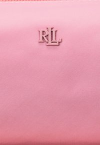 Bolsita de tela texturizada rosa con un logo en relieve "RL" en rosa a juego. El diseño es sencillo con un acabado suave.