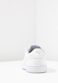 Sneaker bianca in pelle con forma arrotondata, collare leggermente imbottito e sottili accenti grigi. Suola testurizzata per aderenza e supporto.