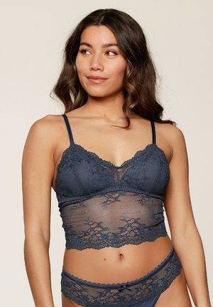Navy kant bralette met doorschijnende meshdetails, verstelbare bandjes, golvende randen en een bloemenpatroon. Gepaard met bijpassende kant brief.