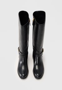Black leather knee-high boots with a sleek design, featuring a rounded toe, gold hardware accents, and side zippers for easy wear.