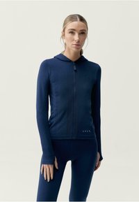 Jūras spēku zip-up kapuce ar teksturētām paneļiem un pieguļošu dizainu, ar kapuci un garām piedurknēm. Audums ir gluds un elastīgs.