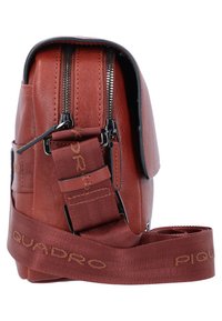 Borsa a tracolla in pelle marrone con due scomparti con zip, tracolla regolabile e dettagli con logo sulla tracolla. Texture liscia.