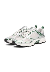 Baskets de sport blanches texturées avec des accents verts, des panneaux en maille et une semelle rembourrée. Présentent des lacets et une languette à l'arrière.