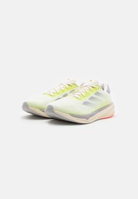 Lightweight athletic shoes with a mesh upper in lime green and white, featuring a cushioned sole and grey accents. Thin laces and a low profile design.
