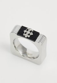 Square silver ring with vertical black ridges on top and a centered ornate silver cross detail.