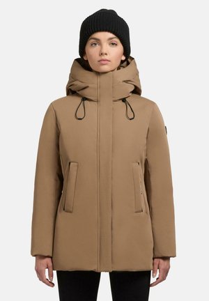 Bruine geïsoleerde parka jas met een capuchon, trekkoorden en zijzakken met rits. Glad aanvoelende textuur en een normale pasvorm. Zwarte gebreide beanie gedragen.