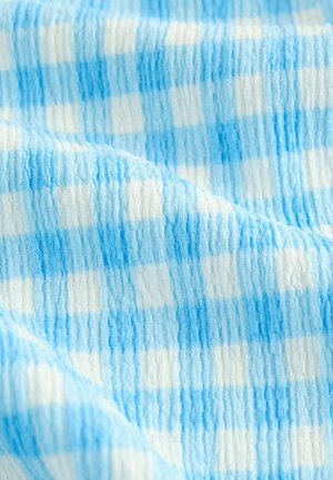 Blue and white checkered fabric with a textured surface, featuring alternating stripes of solid and patterned areas, creating a soft appearance.