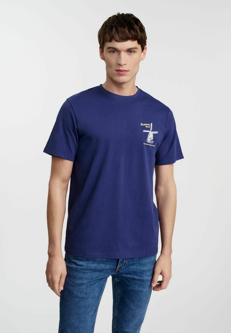 Granatowa bawełniana koszulka z krótkim rękawem. Posiada mały nadruk graficzny na lewej piersi. Klasyczny krój z okrągłym dekoltem.