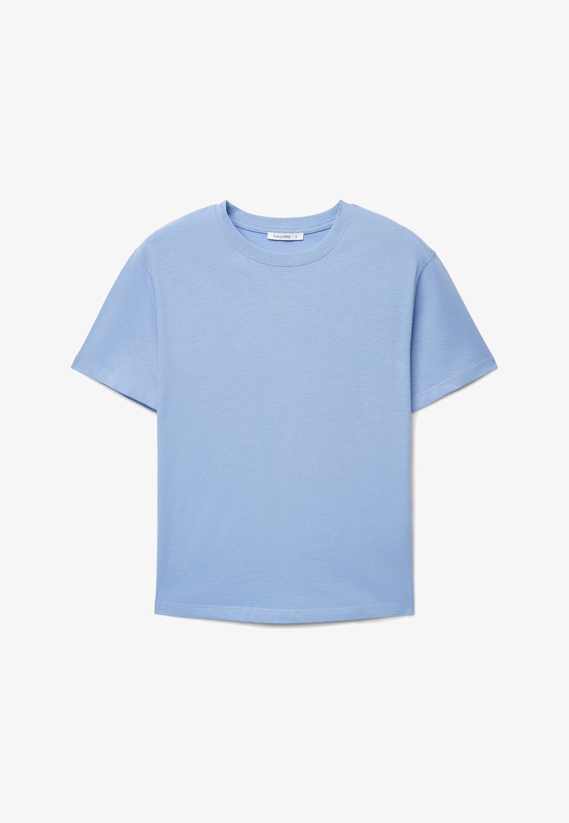 Maglietta semplice di cotone a maniche corte di colore azzurro chiaro, con scollo rotondo e senza motivi o loghi visibili, distesa su uno sfondo bianco.