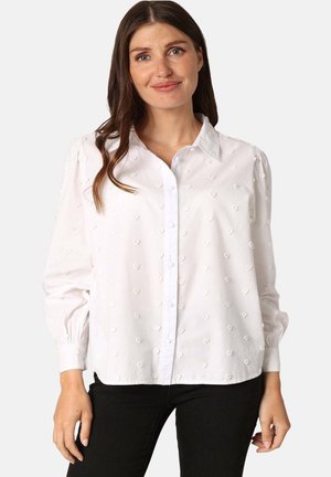 Chemise blanche à boutons avec un motif texturé de petits cœurs, manches longues avec poignets froncés et col classique.