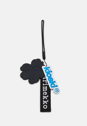 Nøglekæde med en sort blomstformet charme, et sort stofmærke med hvid tekst "Marimekko" og et blåt plastikmærke med "kioski" logo.