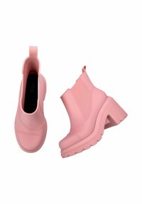 Stivaletti rosa alla caviglia realizzati in materiale lucido, con pannelli laterali elastici e un tacco spesso con suola texturizzata.