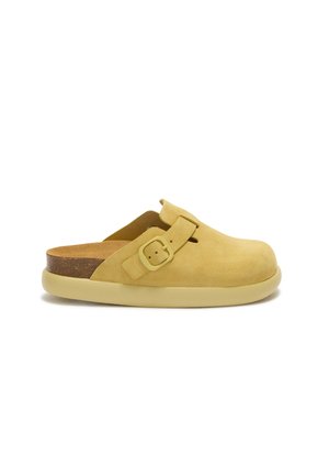 Sabot jaune en daim sans lacets avec boucle latérale réglable et semelle épaisse beige, vue de profil sur fond blanc.