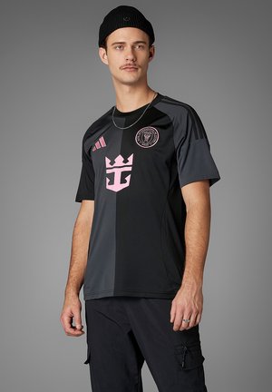 Maglia atletica nera e grigia a maniche corte, con accenti del logo rosa e un design a pannelli a contrasto. Realizzata in tessuto leggero.