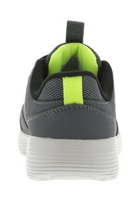 Chaussure de sport grise avec une tige texturée, des accents verts contrastants, une languette au talon et une semelle en caoutchouc blanche.