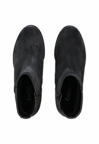 Bottines en daim noir avec une finition lisse, dotées de fermetures éclair latérales et d'un bout arrondi. Design minimaliste sans accents de matériel visibles.