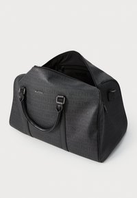 Saco de desporto preto texturizado com padrão tonal do logo, fecho de zíper no topo, alças duplas e um bolso com zíper lateral. O interior inclui um bolso com zíper.